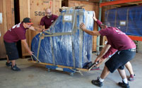 The Poulos Moving Sytems team moving a piano.